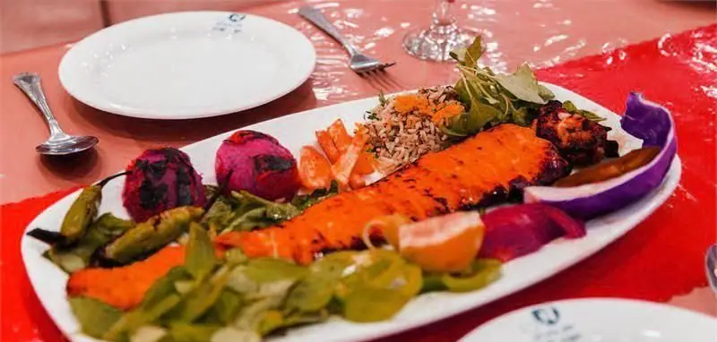 رستوران نمونه تهران: ماهی سالمون گریل ممتاز با برنج، فلفل کبابی و سبزیجات تازه. بهترین غذای ایرانی و کبابی لذیذ را تجربه کنید.