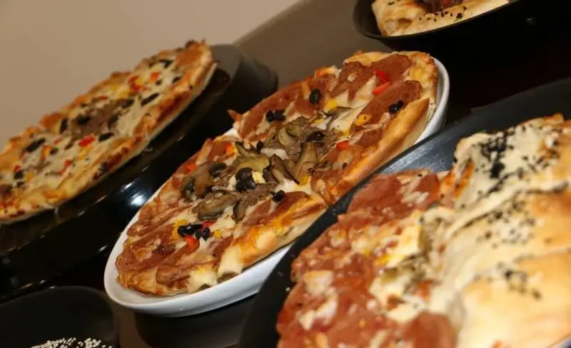 مجموعه‌ای از پیتزاها و نان‌های فست فود آرام برگر با تاپینگ‌های متنوع از جمله پپرونی، قارچ، زیتون، فلفل دلمه و پنیر فراوان