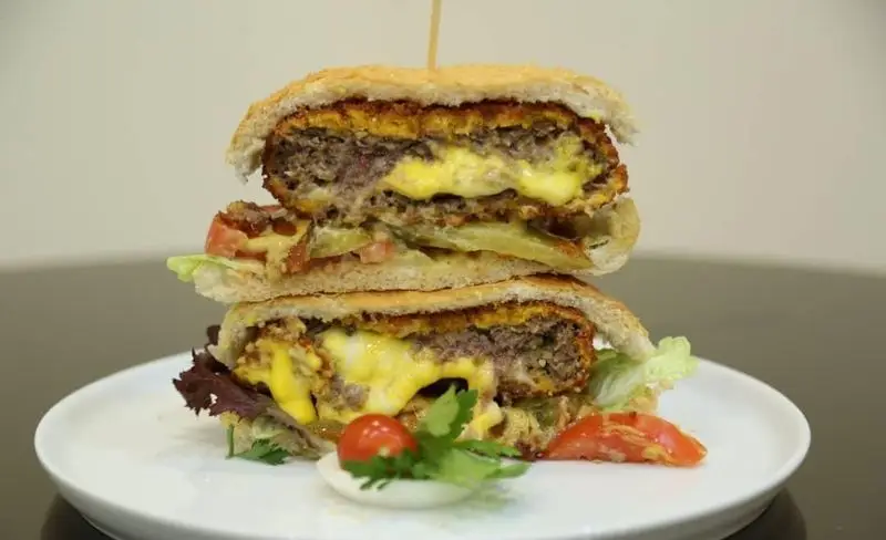 همبرگر دبل پنیر آب شده و گوشت دست‌ساز آرام برگر با کاهو و گوجه فرنگی تازه. یک ساندویچ خوشمزه و پرملات.