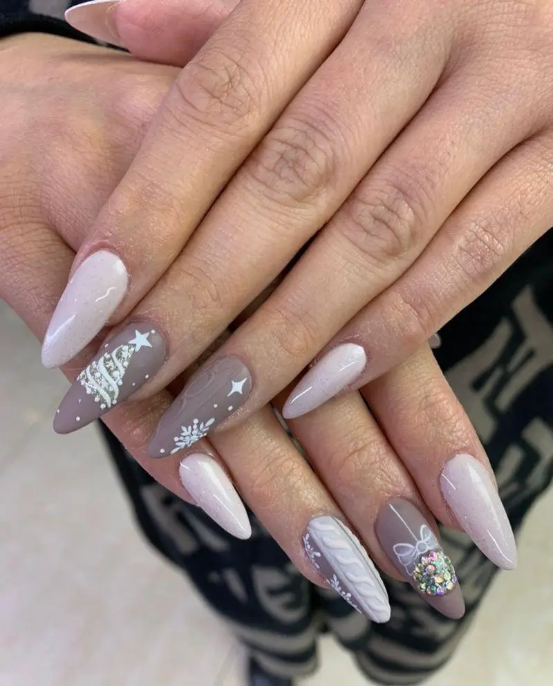طراحی و کاشت ناخن زمستانی با طرح‌های کریسمس، درخت کاج، برف و بافت برجسته روی لاک‌های سفید و قهوه‌ای در سالن زیبایی موزا