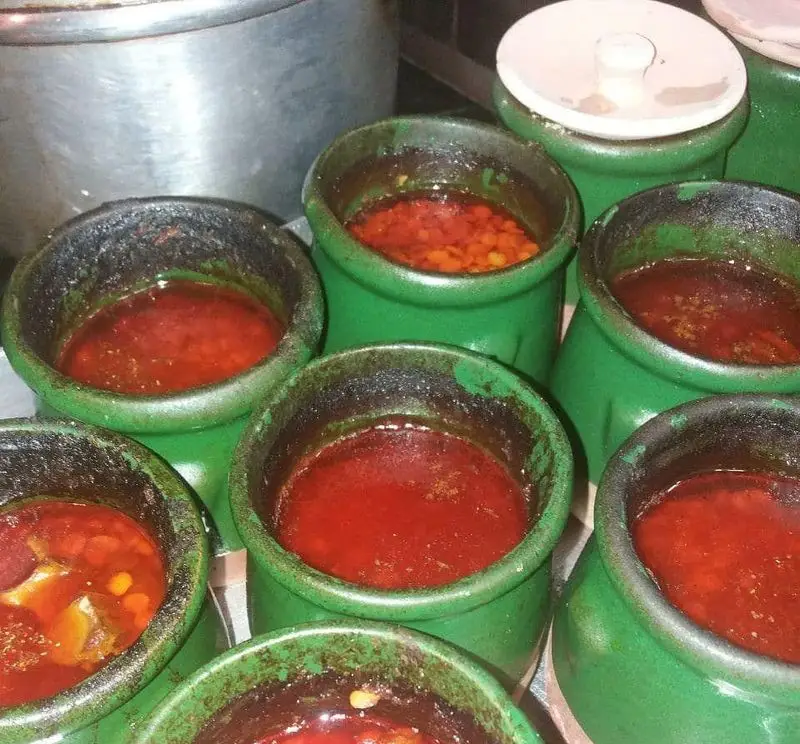 ترشی و سس‌های خانگی و خوش‌طعم در ظروف سفالی سبز، آماده سرو در رستوران نارنج، تجربه‌ای اصیل از طعم‌های محلی