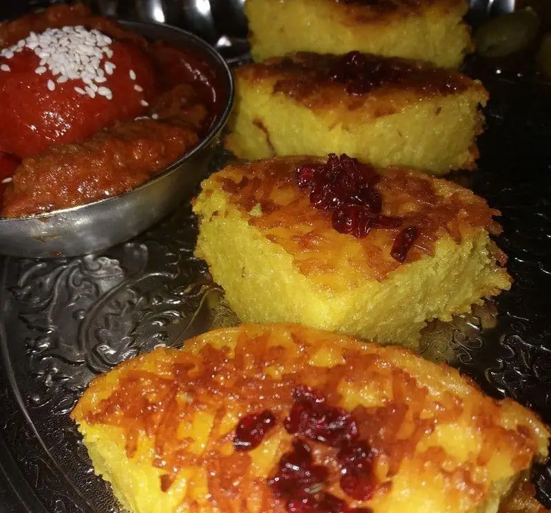 تصویری جذاب از ته چین زعفرانی طلایی با زرشک و خورش اصیل ایرانی، انتخابی بی‌نظیر در رستوران نارنج.