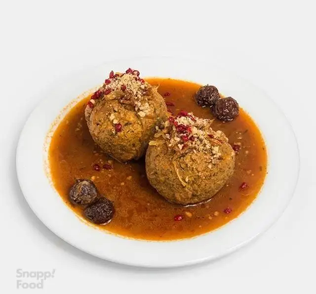 سفارش کوفته تبریزی اصیل و مجلسی با سس غلیظ و آلو، تزئین شده با زرشک و مغز، از منوی ویژه کترینگ بزرگ آریانا.