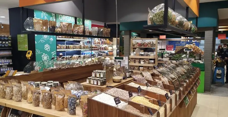 فضای داخلی فروشگاه دی مارت، بخش محصولات طبیعی، ارگانیک و فله. انواع خشکبار، غلات، دانه ها و ادویه جات برای خریدی سالم.