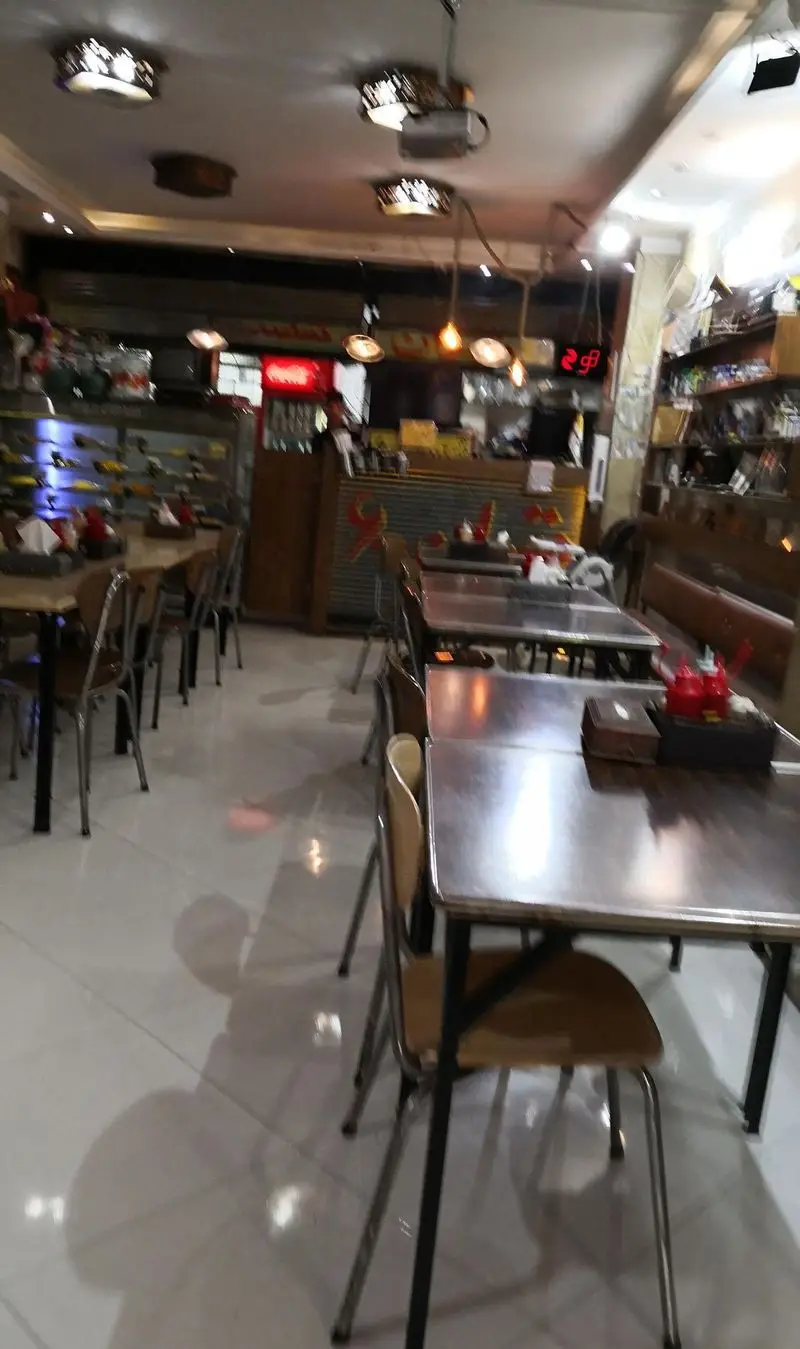 فضای داخلی رستوران اغذیه‌ فروشی تهران۶۰: میز و صندلی‌های مرتب، نورپردازی دلنشین و دکوراسیون جذاب برای یک تجربه غذایی عالی در تهران.