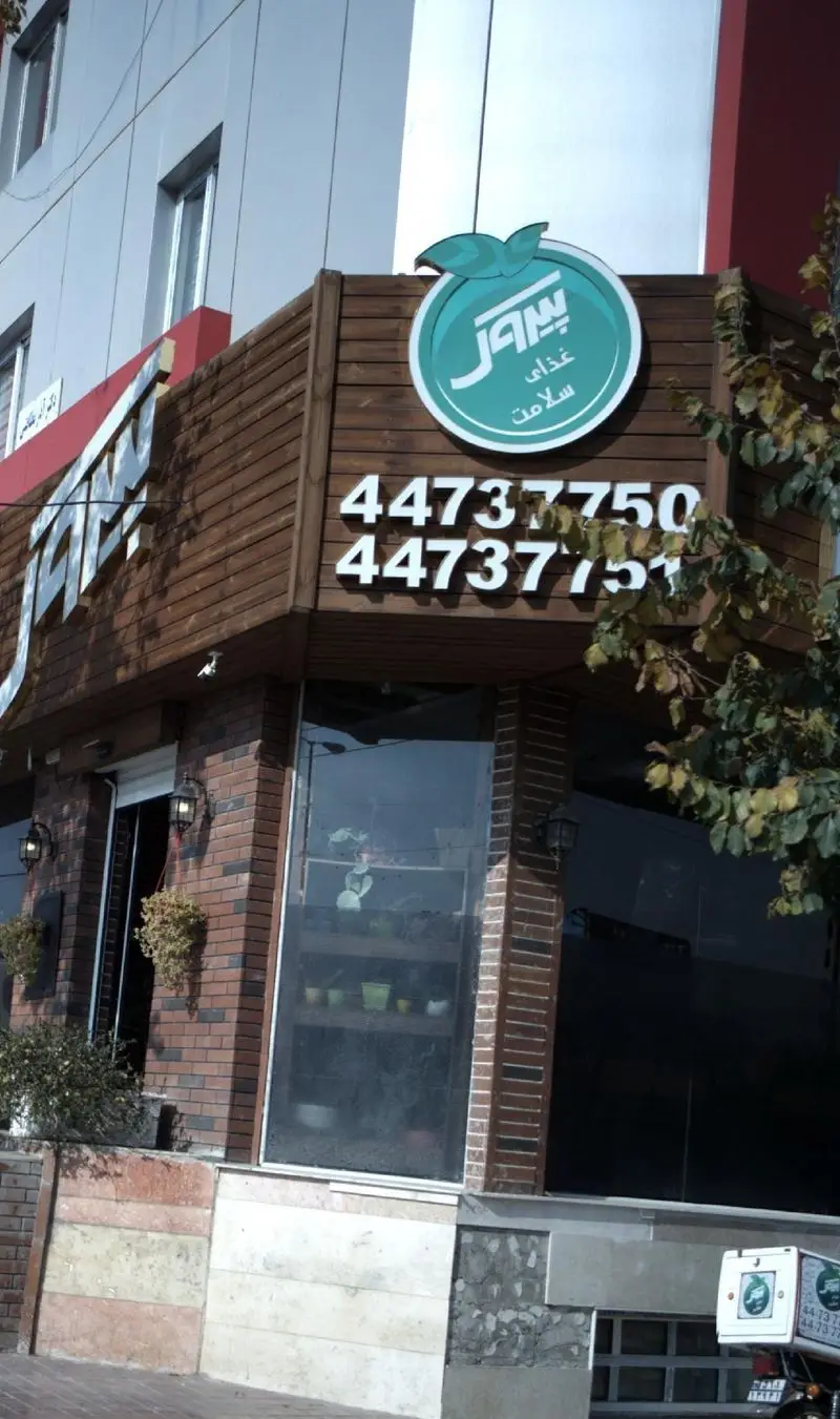 تصویر نمای بیرونی رستوران پیتزا پیروک با تابلوی اصلی حاوی لوگو و عبارت غذای سلامت، به همراه شماره‌های تماس ۴۴۷۳۷۷۵۰ و ۴۴۷۳۷۷۵۱.