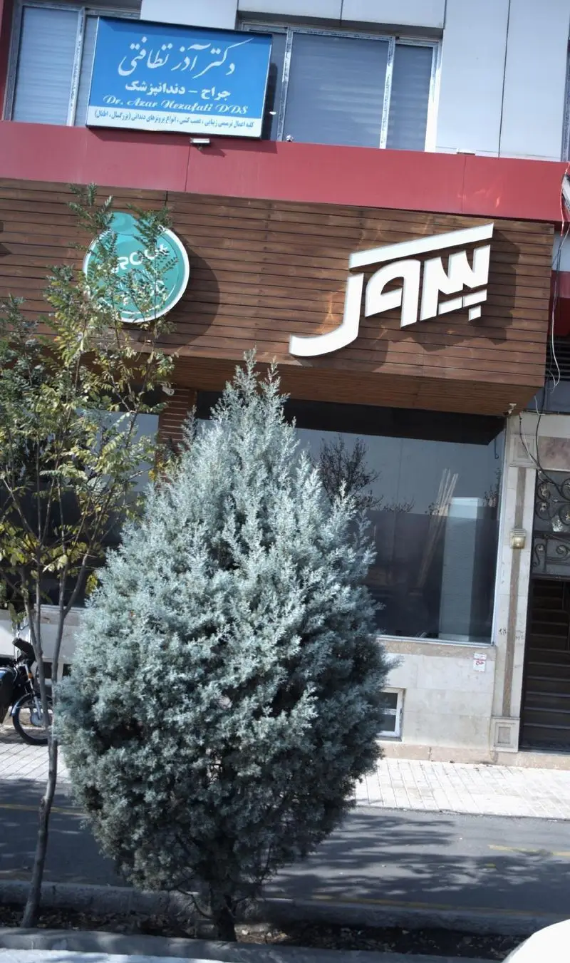 نمای جذاب پیتزا فروشی پیروک در یک روز آفتابی، تابلوی بزرگ و زیبا روی نمای چوبی، با درختان سرسبز در جلوی ورودی ساختمان.