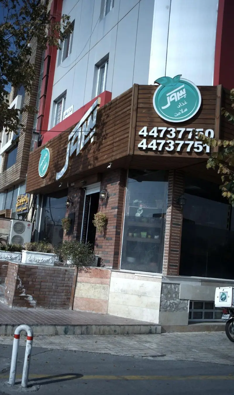 پیتزا پیروک: نمای بیرونی رستوران غذای سلامت با لوگوی سبز، ورودی و شماره تماس‌های ۴۴۷۳۷۷۵۰ و ۴۴۷۳۷۷۵۱ برای سفارش غذا.