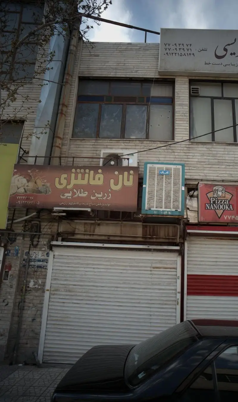 تابلو نان فانتزی زرین طلایی با ارائه انواع نان فانتزی و رژیمی، به همراه شماره‌های تماس ۷۷۲۴۶۱۷۶ و ۰۹۱۲۳۶۷۴۶۱۵.