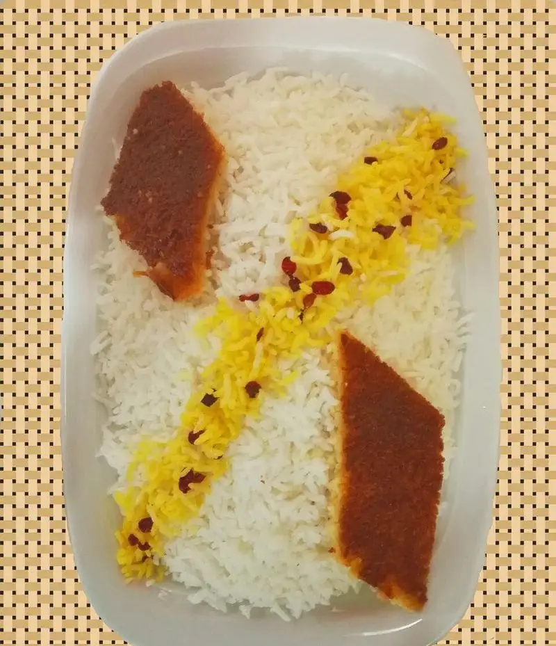 چلو با ته دیگ برشته و زرشک پلو زعفرانی، تزیین شده با زرشک، از رستوران ایرانی شاندیز ماهان.