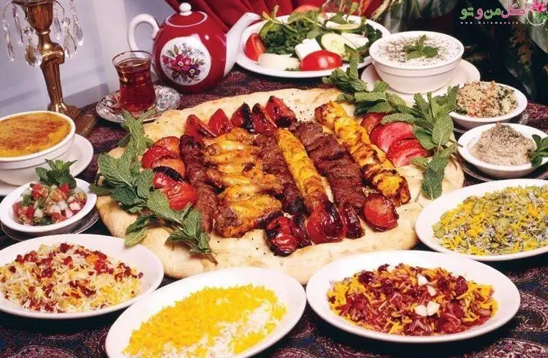 میز باشکوه غذای سنتی ایرانی با انواع کباب، زرشک پلو، باقالی پلو، سالاد و پیش‌غذا در سفره خانه سنتی آب وآتش.