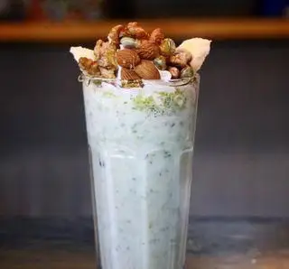میلک شیک پسته و موز بستنی بابا علی، نوشیدنی خنک و مقوی با آجیل‌های تازه (بادام، گردو، پسته) و خامه. طعمی بی‌نظیر و سالم.