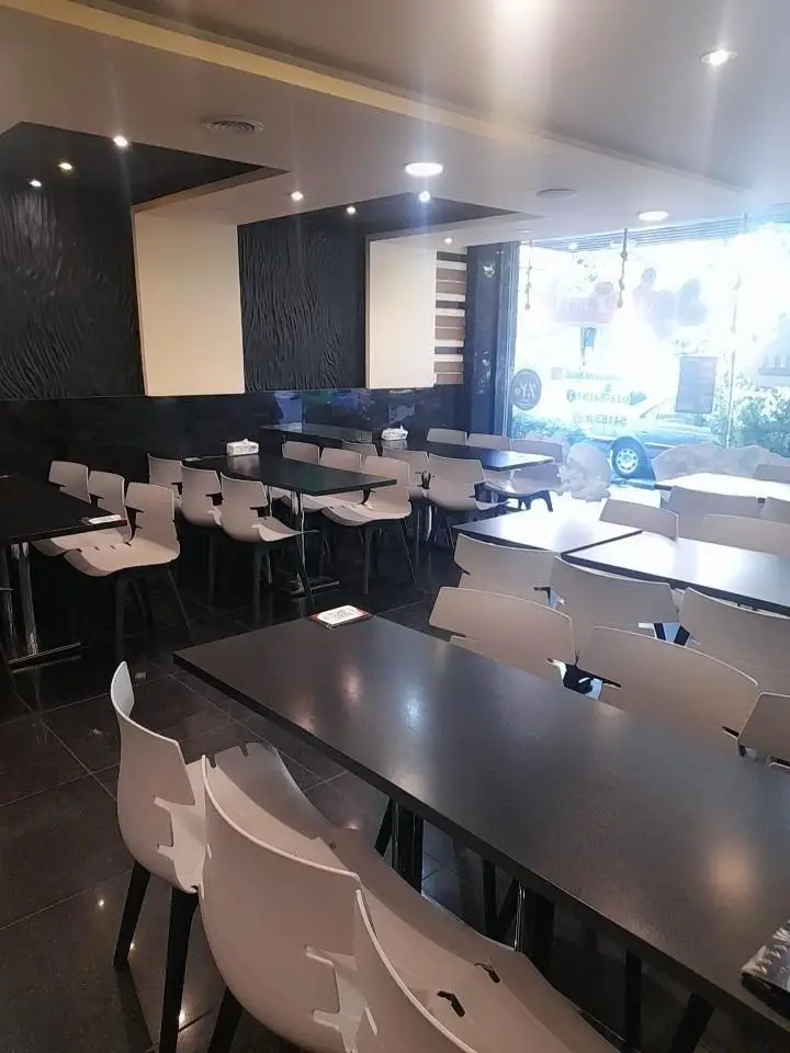 تصویر واضح از فضای داخلی رستوران پیانو با میز و صندلی‌های مدرن، دیوارهای طرح‌دار و پنجره‌های بزرگ، محیطی دلنشین برای غذا.