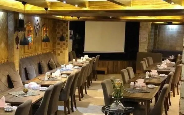 تصویری از فضای داخلی سفره خانه سنتی صوفی با چیدمان میز و صندلی‌های راحت و دکوراسیون سنتی و آرامش‌بخش برای مشتریان.