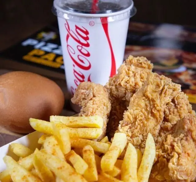 مرغ سوخاری ترد و خوشمزه از چیکن به همراه سیب‌زمینی سرخ‌کرده طلایی، نان و نوشابه کوکا کولا.