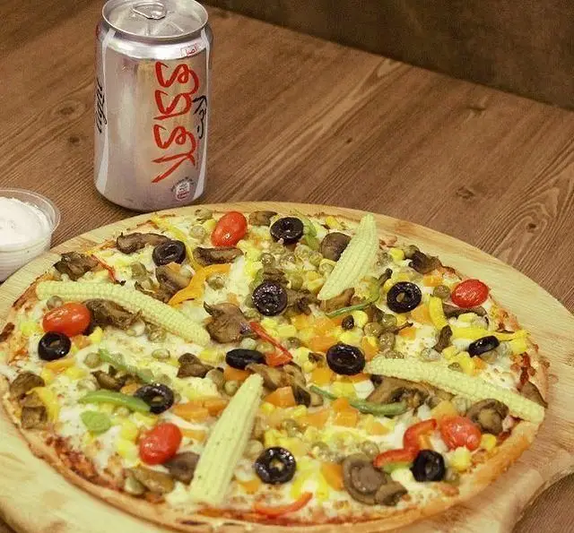 تصویری از پیتزا مخصوص سبزیجات با قارچ و ذرت، زیتون و گوجه گیلاسی به همراه نوشابه و سس دلپذیر در مرغ سوخاری چیکن.