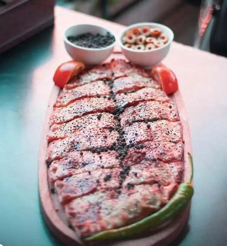 پیده گوشت تازه و خوشمزه رستوران ترکیه ای پیده سرا، با فلفل سیاه، گوجه و فلفل سبز، یک غذای سنتی و لذیذ.