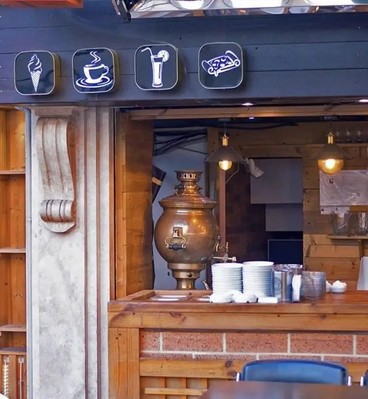 نمای بیرونی رستوران ترکیه ای پیده سرا با تابلوهای بستنی، قهوه، نوشیدنی و پیده/پیتزا. فضای داخلی با سماور سنتی و پیشخوان چوبی.