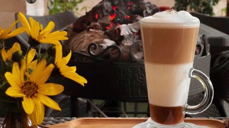 کافی شاپ فرندز: تجربه نوشیدن یک لاته لایه‌ای دلنشین با گل‌های زرد زیبا و گرمای شومینه، محیطی دلپذیر و آرام برای لحظات شما.