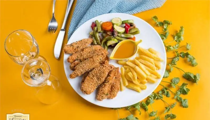 وعده غذایی لذیذ از کافی شاپ لوپتو: چیکن استریپس سوخاری ترد، سیب زمینی سرخ کرده، سبزیجات گریل شده تازه و سس مخصوص.