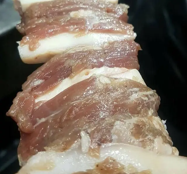 گوشت تازه و باکیفیت برش خورده، شامل لایه‌های یکدست گوشت و چربی، آماده طبخ و گریل در جگرسرای پنج دری.