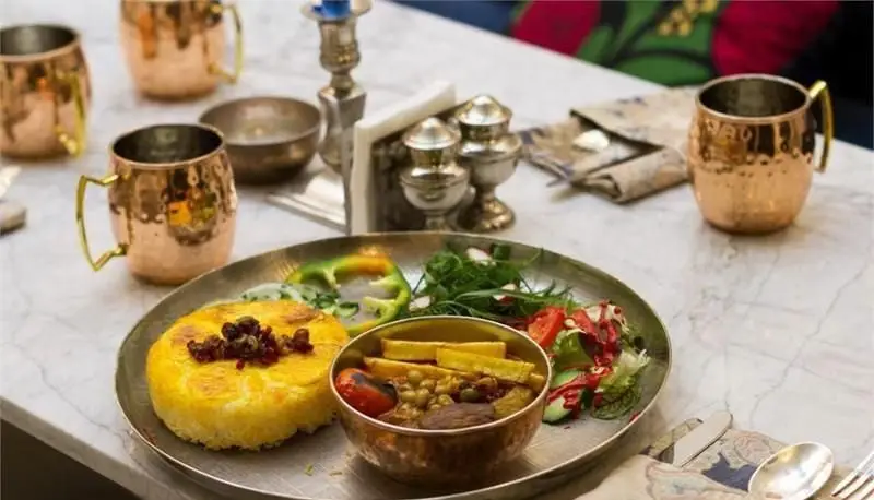 غذای سنتی ایرانی در مطبخ قاجاری: ته چین زعفرانی، خورش و سالاد تازه. تجربه‌ای اصیل از طعم‌های دلنشین قجری در تهران.