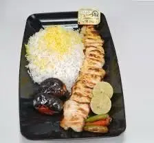 چلو جوجه کباب لذیذ کبابی سیمرغ با برنج ایرانی، گوجه کبابی و لیمو تازه. بهترین غذای سنتی ایرانی برای سفارش در رستوران سیمرغ.