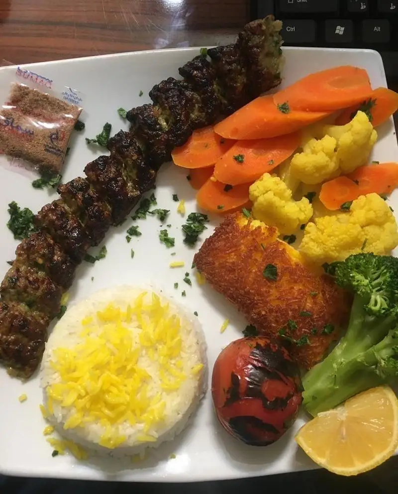 بشقاب کباب خوش‌طعم کبابی سیمرغ با کباب، برنج زعفرانی، هویج، گل کلم، بروکلی، گوجه کبابی، ته دیگ و لیمو. غذای اصیل ایرانی.