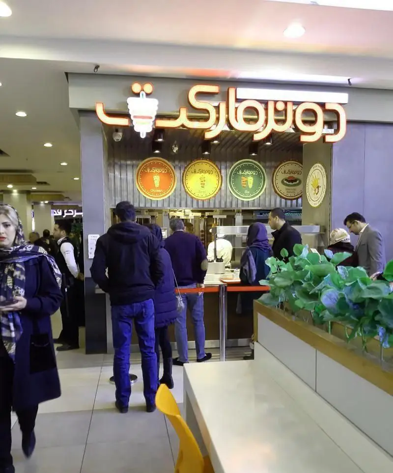 رستوران ترکی دونر مارکت با مشتریانی در حال سفارش در محیطی مدرن، ارائه دهنده لذیذترین دونرهای استانبولی و کباب ترکی اصیل.