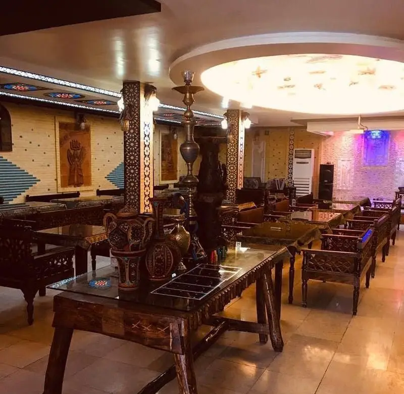 فضای داخلی دنج و سنتی رستوران تخت جمشید، با مبلمان چوبی، دکوراسیون ایرانی خاص و قلیان، مناسب تجربه ای متفاوت.
