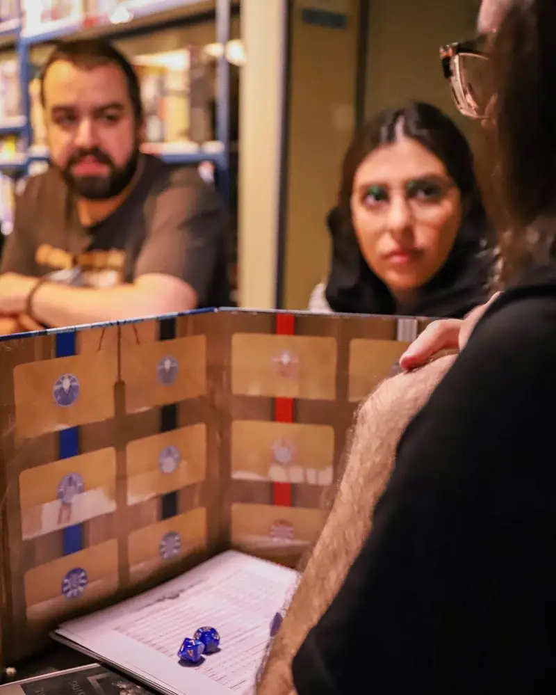 تصویری جذاب از دورهمی و تجربه هیجان‌انگیز بازی‌های رومیزی نقش‌آفرینی در کافه برد. محیطی دوستانه برای بهترین سرگرمی‌ها.