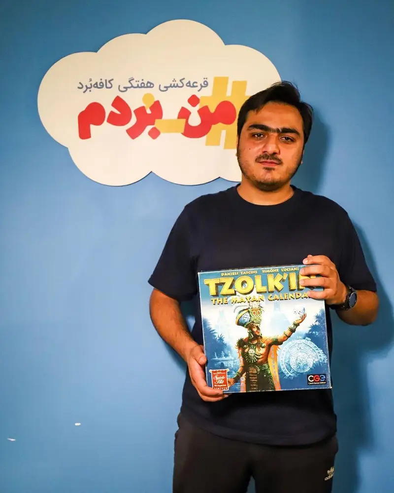 عکس مرد جوانی برنده خوشحال قرعه کشی هفتگی کافه برد، با جایزه بازی رومیزی Tzolk'in: The Mayan Calendar