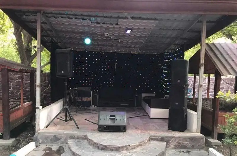 صحنه زیبای فضای باز رستوران ایرانی آرامیس، مجهز به سیستم صوتی و نورپردازی حرفه‌ای برای اجرای موسیقی زنده و برنامه‌های تفریحی.