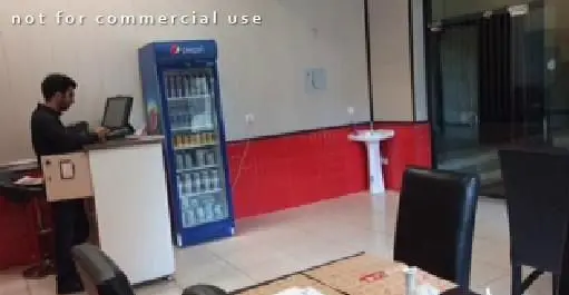 تصویری از پرسنل مستر دیزی در حال کار با سیستم سفارش‌گیری، همراه با یخچال نوشیدنی و محیط داخلی رستوران.