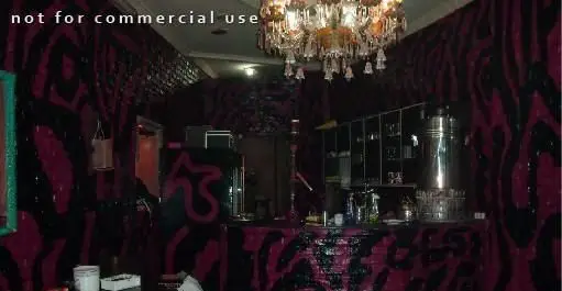 دکوراسیون داخلی منحصربفرد رستوران ایرانی زند؛ طرح‌های فانتزی صورتی و مشکی، لوستر کریستالی مجلل و بار نوشیدنی.