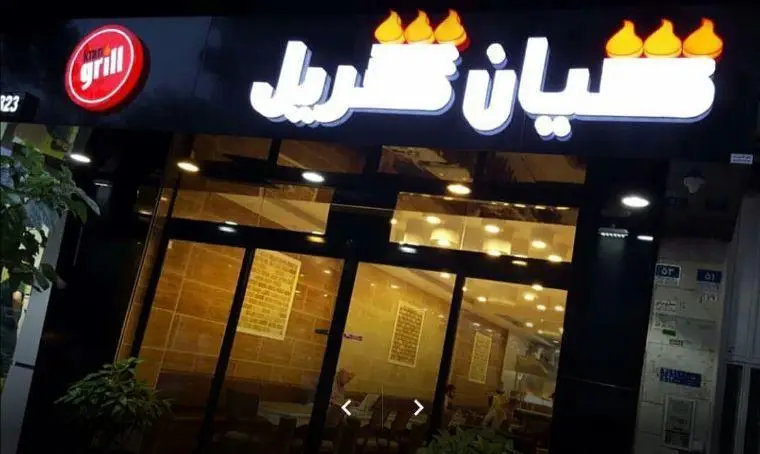 تصویر نمای شبانه و جذاب از سردر فست فود و رستوران کیان گریل با تابلو و نورپردازی حرفه‌ای و لوگوی انگلیسی و فارسی.