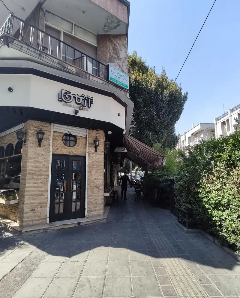 تصویری از نمای بیرونی کافه کباب آرمنیا، یک کافه رستوران با سنگ‌کاری جذاب، درب ورودی شیک و بالکن، در خیابانی آفتابی.