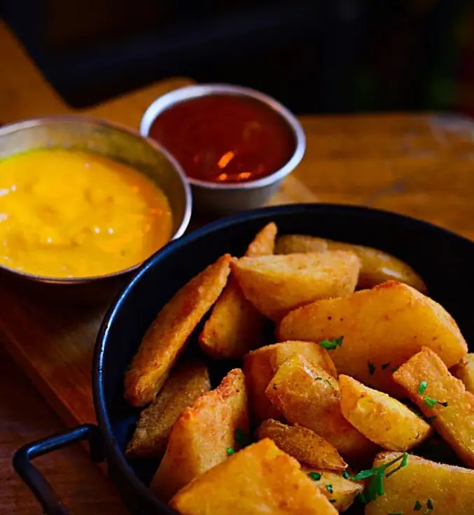 سیب‌زمینی وِج طلایی و خوشمزه کافه کباب آرمنیا، بهترین پیش‌غذا یا کنار غذا برای کباب و برگر، همراه با سس‌های متنوع و لذیذ.