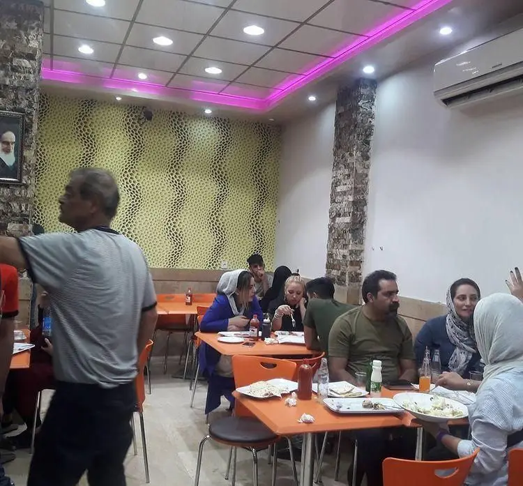 تصویری از داخل فست فود شاورما سان وی با مشتریان در حال صرف غذا، فضایی دنج و مدرن برای تجربه طعم لذیذ شاورما.