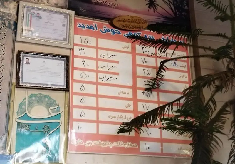 منوی طباخی بره کوهی با لیست قیمت سرویس کله‌پاچه، گوشت، مغز، زبان، بناگوش، آب معدنی و چای، همراه با مدارک کاری روی دیوار.