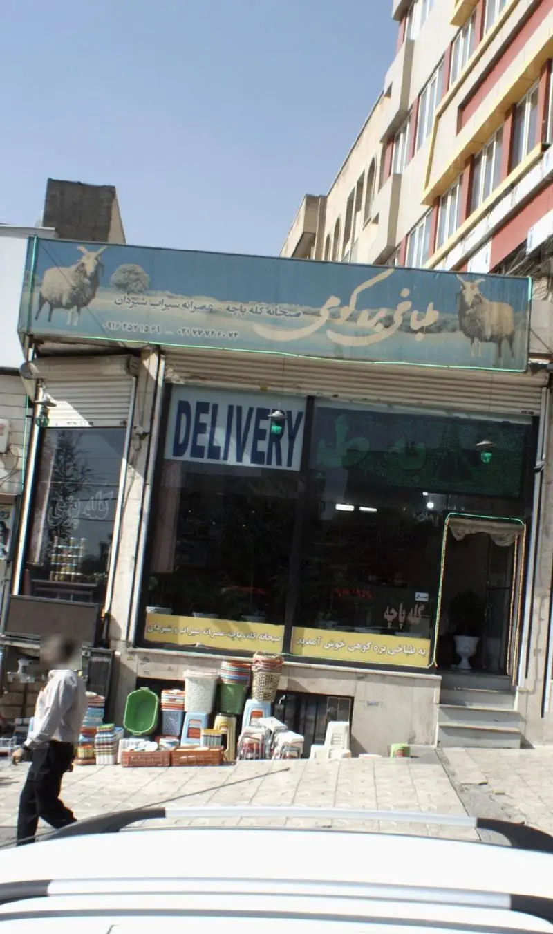 نمای بیرونی طباخی بره کوهی با تابلوی آبی رنگ، ارائه دهنده صبحانه کله پاچه و عصرانه سیراب شیردان با امکان دلیوری در خیابان.