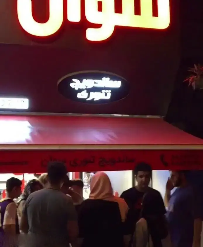 نمای بیرونی فروشگاه بستنی کابانا در شب، با تعداد زیادی از مشتریان حاضر و نورپردازی روشن و جذاب برای جلب توجه.