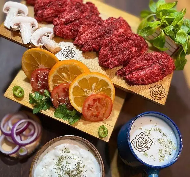 تصویری از جگر مزه‌دار شده و تازه جگرسرای عیاران همراه با قارچ، پرتقال، گوجه، پیاز، فلفل، ماست و دوغ محلی. جگرکی عیاران.