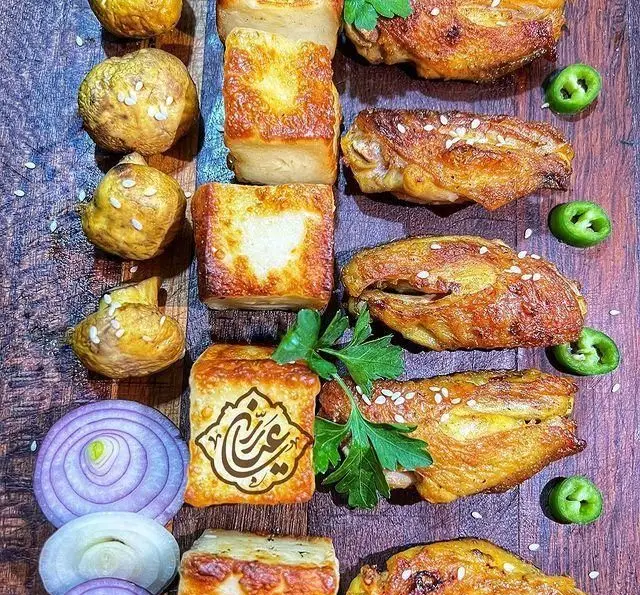 سینی غذای خوشمزه جگر سرای عیاران: جگر کباب، بال مرغ برشته، نان داغ، پیاز، فلفل و سبزی. بهترین جگر و کباب با کیفیت عالی.