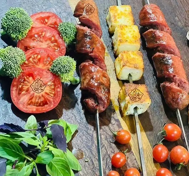 کباب‌های لذیذ جگر سرای عیاران شامل کباب جگر، پنیر کبابی، گوجه‌فرنگی، بروکلی و سبزی تازه، انتخابی عالی برای عیاران.
