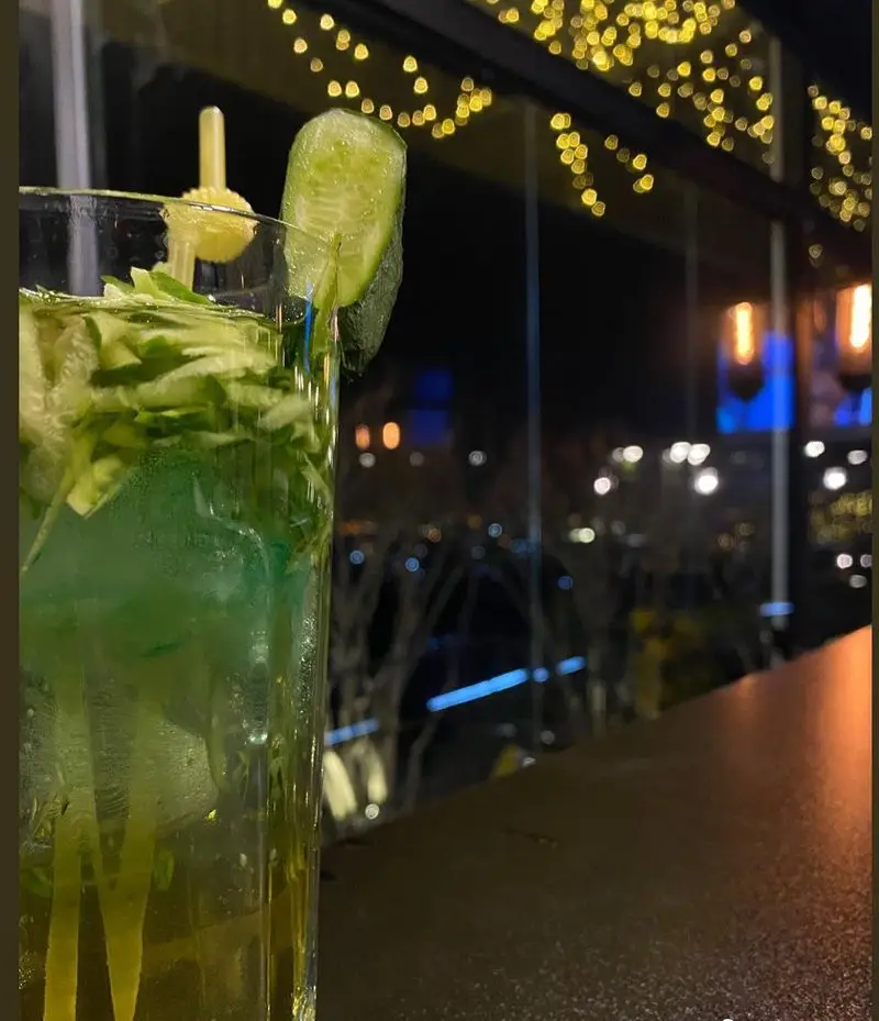 نوشیدنی خنک و دلپذیر خیار در کافه رستوران لمیاء. لحظات آرام و شب‌نشینی بی‌نظیر با منظره شهری زیبا و فضای دنج کافه رستوران.