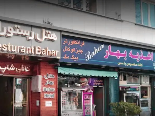 تصویری از نمای بیرونی ساندویچی و اغذیه بهار، با منوی شامل فرانکفورتر، چیز کوکتل، بیگ مگ و دیگر غذاهای فست فود.