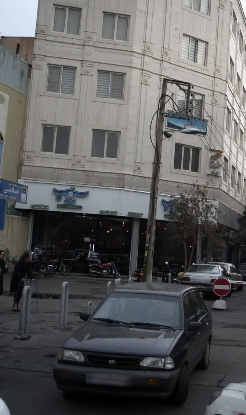 نمای واضح از شعبه پیتزا سیب ۳۶۰ در روزی نیمه‌ابری، با تابلو و ویترین جذاب و جنب و جوش خیابان.