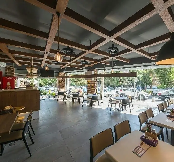 فضای داخلی دلباز و مدرن پیتزا سیب ۳۶۰ با سقف چوبی، میز و صندلی‌های شیک و منظره خیابان، محیطی عالی برای لذت بردن از پیتزا.