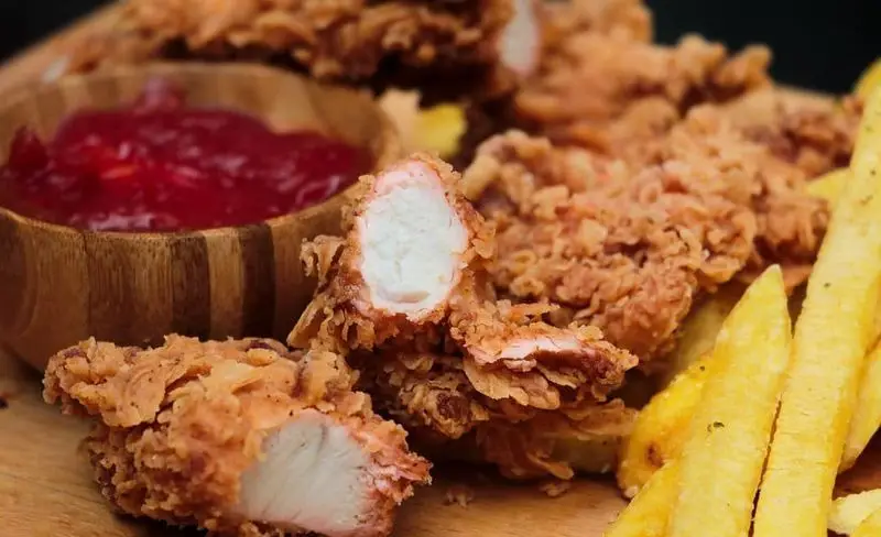 تندرهای مرغ سوخاری کریسپی شیلا با سس قرمز و سیب زمینی سرخ کرده طلایی، انتخابی عالی برای یک وعده غذای سریع و خوشمزه از فست فود شیلا.